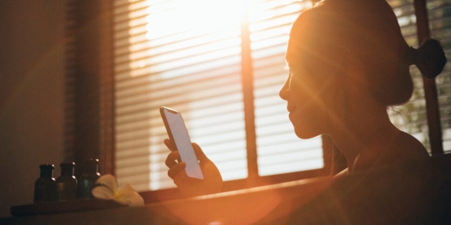 woman looking at phone in sunlight